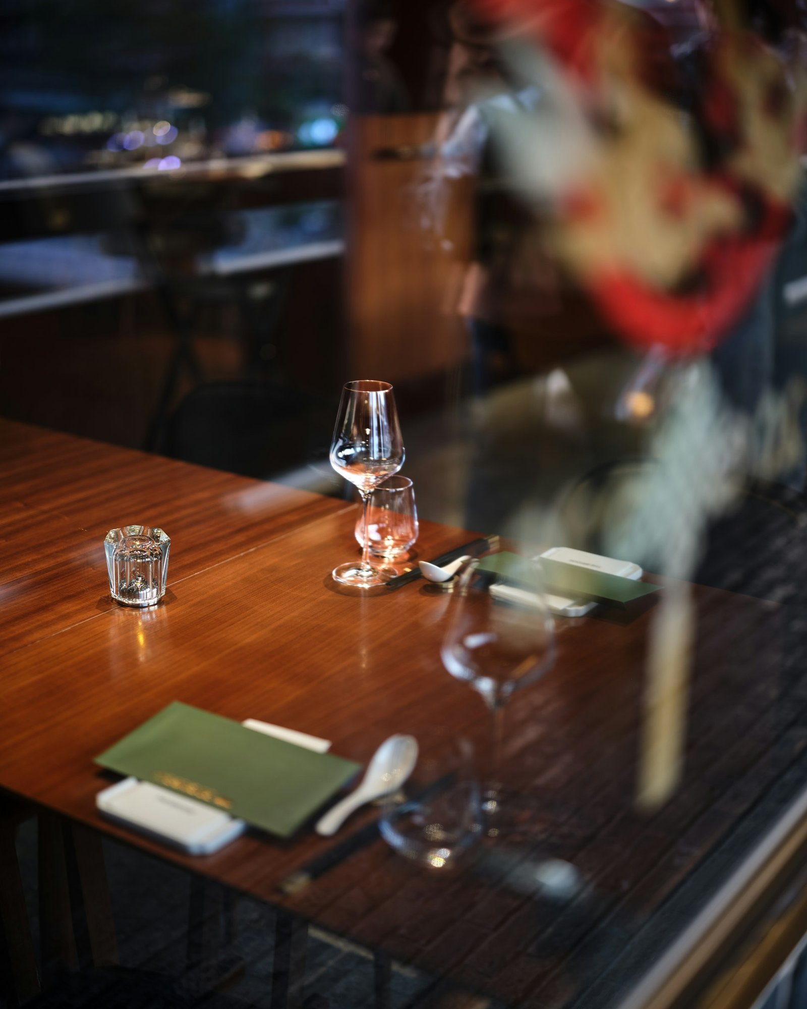 An elegant fine dining table setting with wine glasses and menus